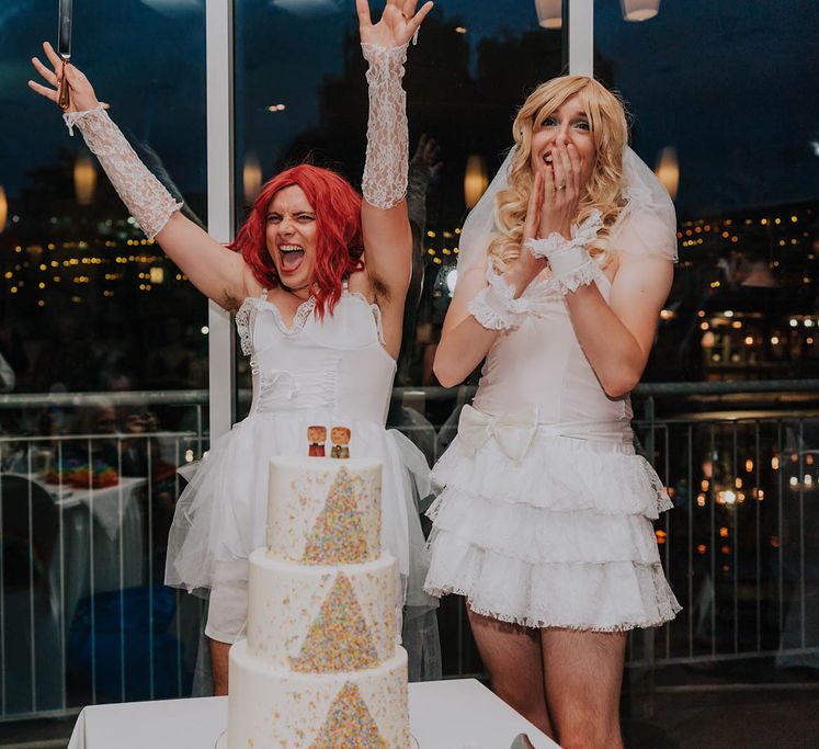 Grooms celebrate whilst wearing drag clothing in wedding gowns and wigs on their wedding day | Kim Williams Weddings