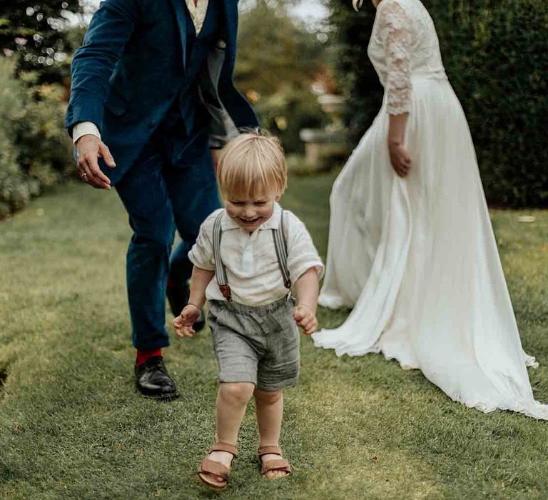 Cute page boy in short dungarees at Cadhay House wedding