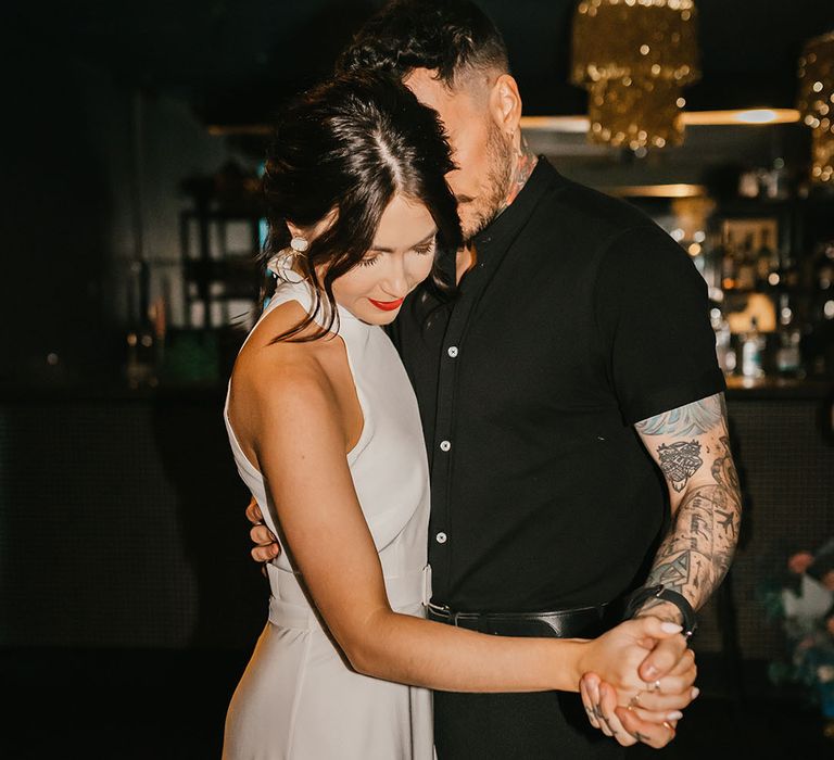 First dance with groom in a black short sleeve shirt and bride in a halterneck wedding dress with red lipstick 