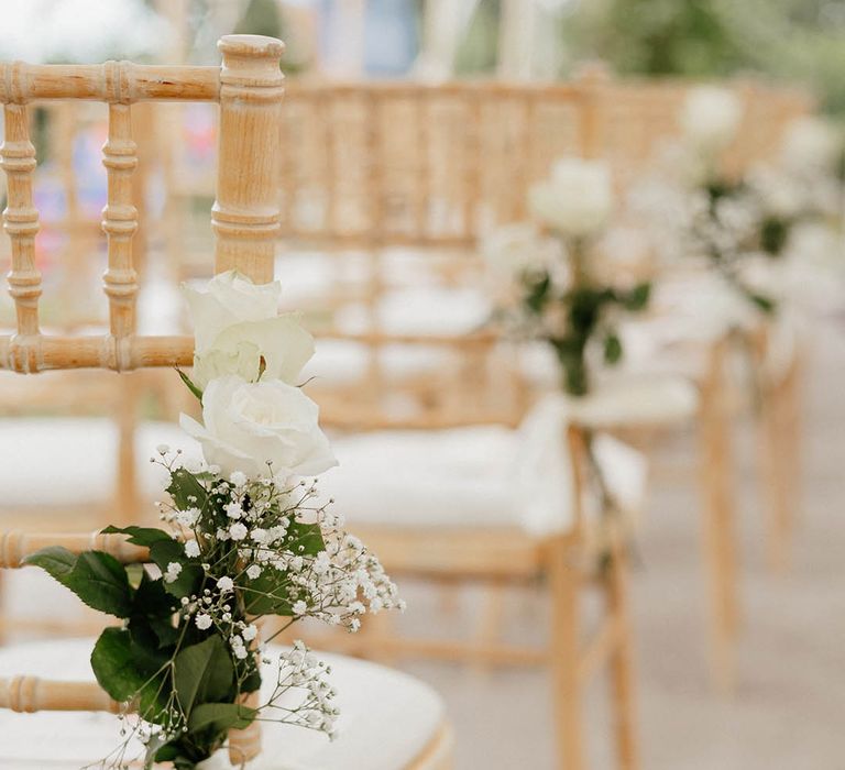 Wooden wedding chair complete with florals and green foliage