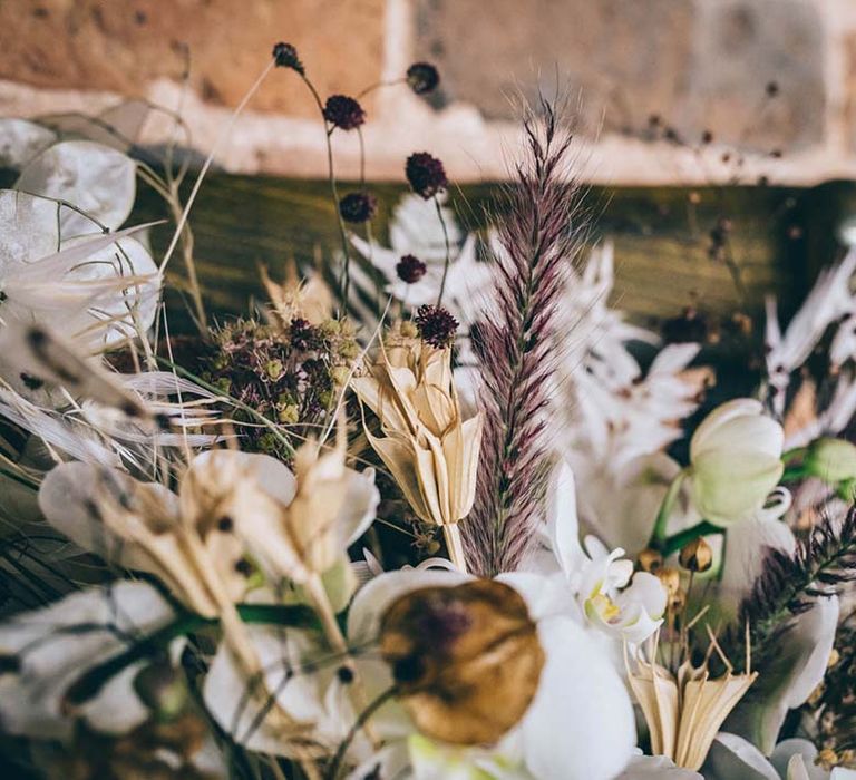 Dried grasses and foliage and fresh orchid flower wedding bouquet 