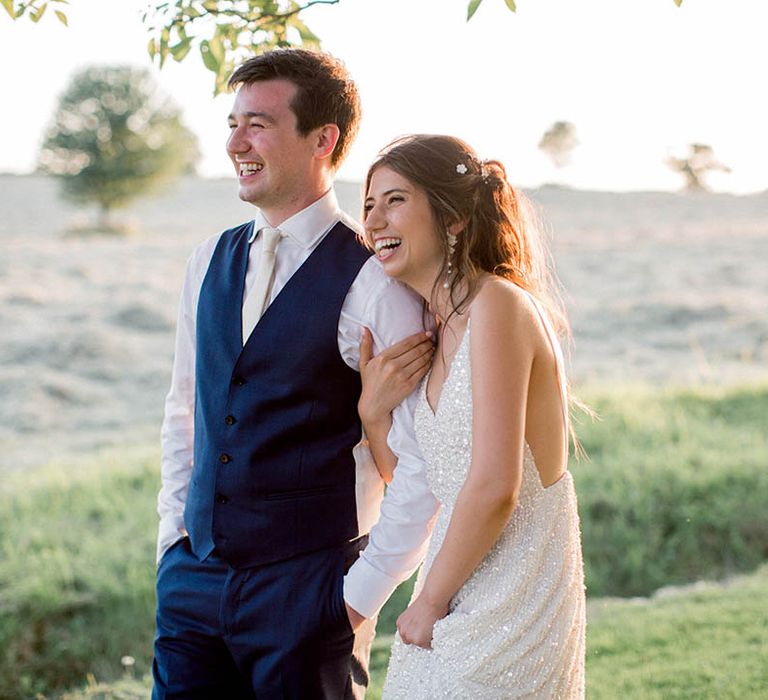 Bride & groom stand with one another on their wedding day outdoors