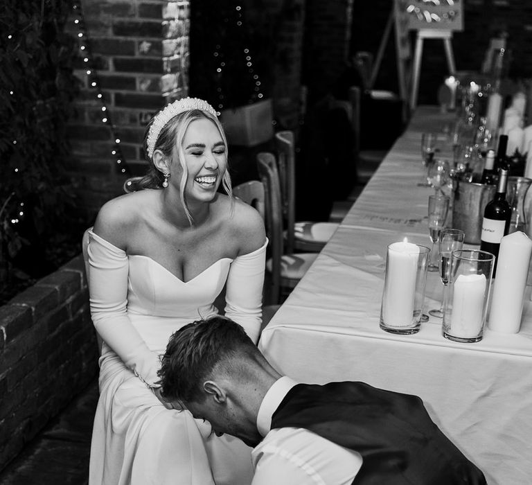 Groom tying up the laces on the bride trainers 