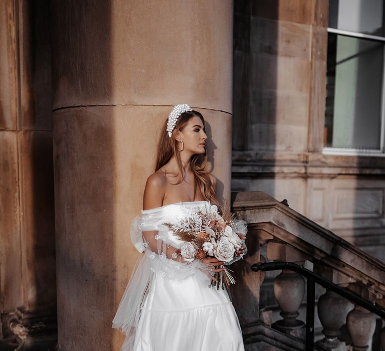 Bride in a layered tulle wedding dress with strapless design and butterfly appliqué detail at St. George's Hall, Liverpool 