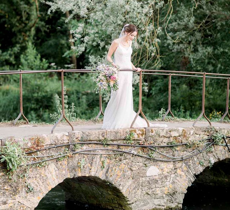 Bride looks over bridge on her wedding day