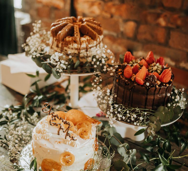 Three single tier wedding cakes with foliage decor and gypsophilia for industrial rustic wedding