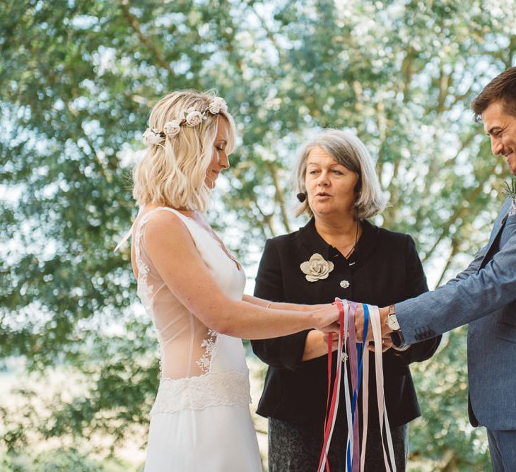 destination wedding with handfasting ceremony with colourful ribbon and bride in a sheer back fitted wedding dress