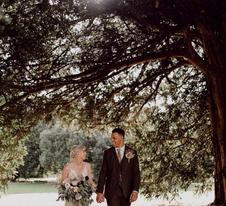 Bride and groom walk around the grounds of their wedding venue together at No.38 The Park