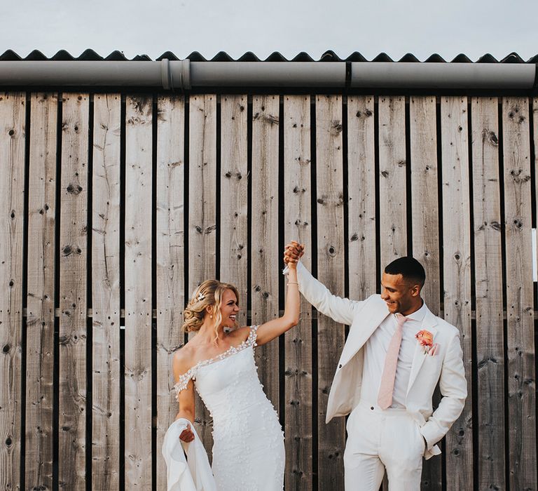 Bride and groom lift up their hands on their wedding day 