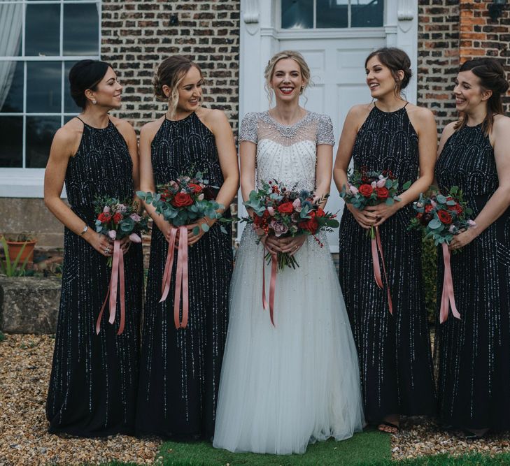 Bridesmaids wear long sparkly black bridesmaid dresses with halter neck styling 