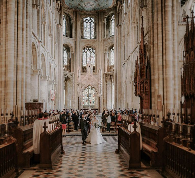 Bride and groom exit through the cathedral as a married couple 