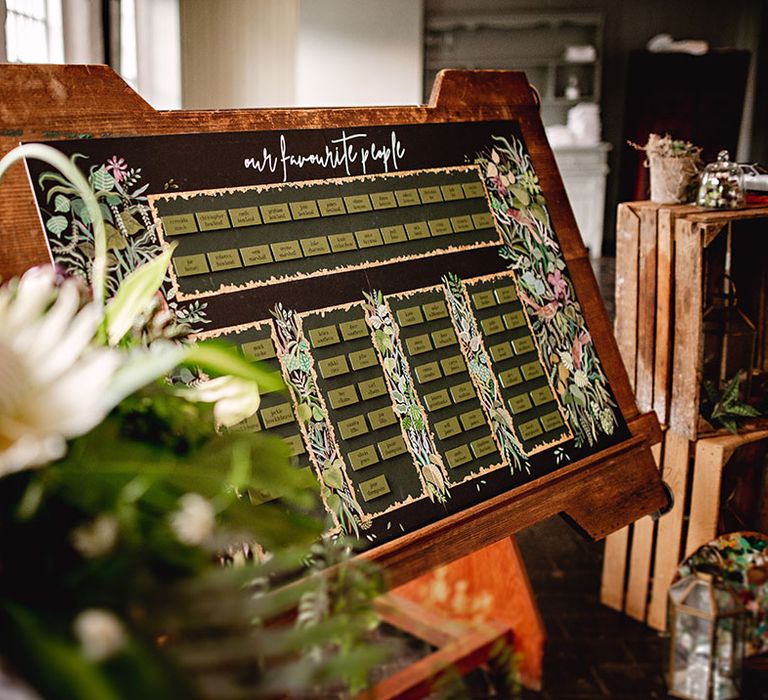 Botanical styled seating chart on wooden board 