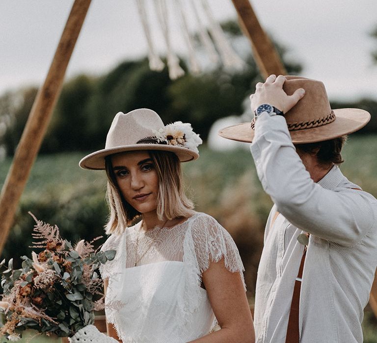 The bride and groom pose together for boho outdoor wedding ceremony 