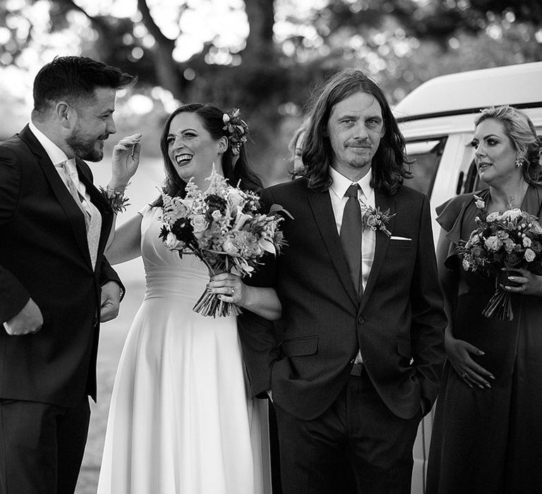 Bride laughing with her wedding party for the festival style outdoor tipi wedding 