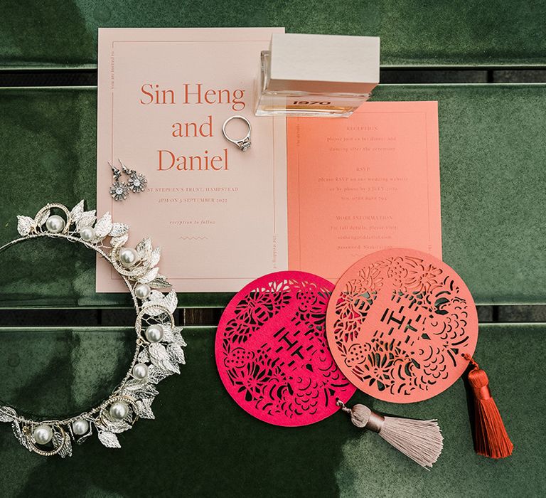 Colourful and modern wedding stationery beside silver embellished bridal crown and perfume 