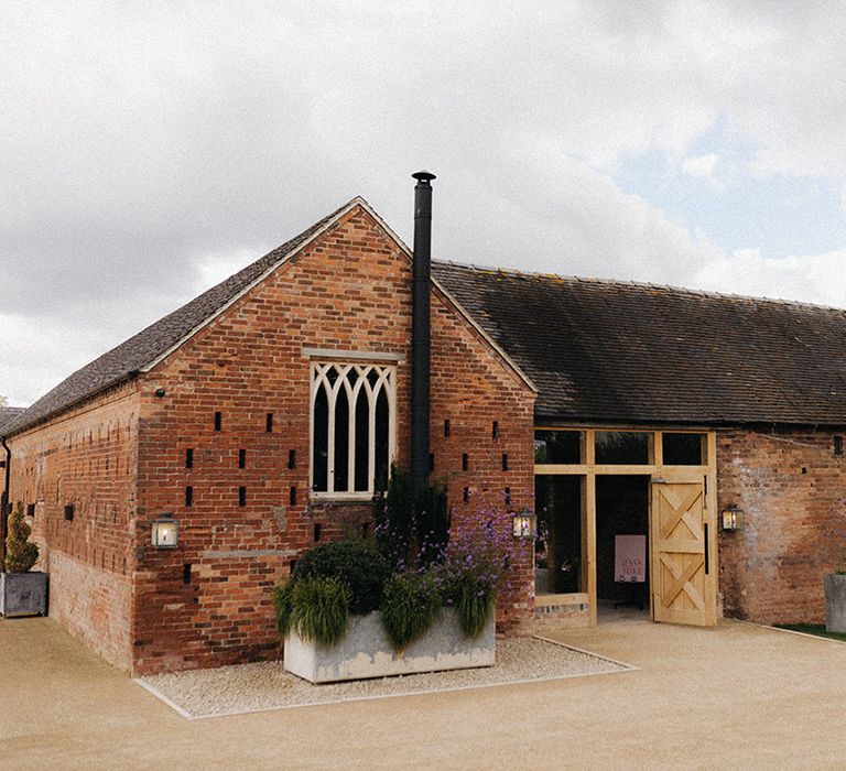 Rustic barn Grangefields wedding venue with pink and red wedding signage 