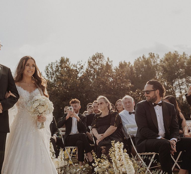 Bride in lace long sleeve Pronovias wedding dress with father of the bride walking down the aisle at fusion destination wedding in Barcelona 