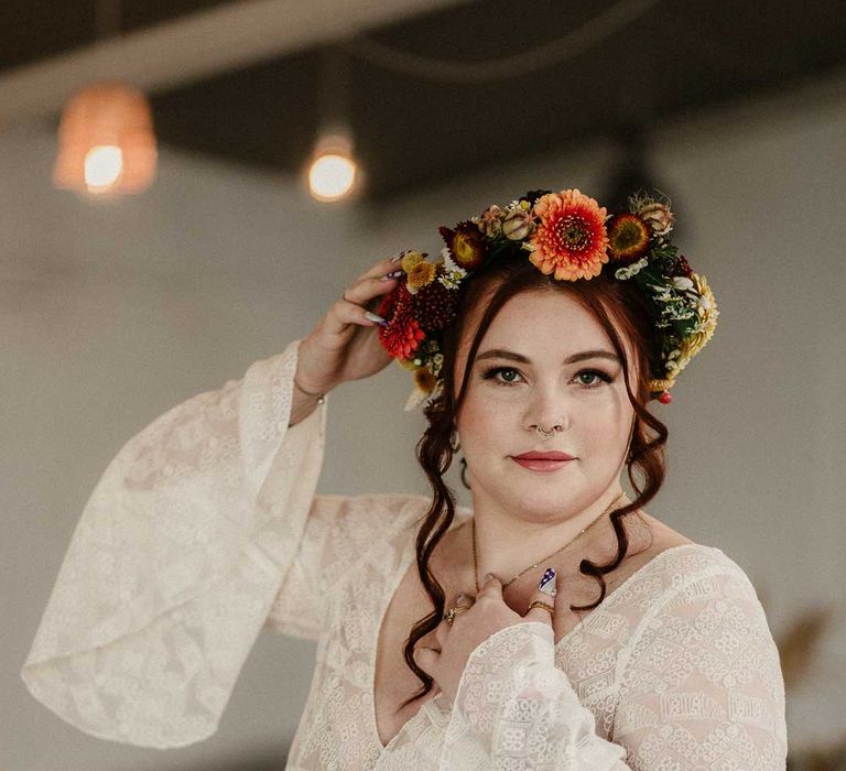 Bride at The Barn at Avington posing, wearing v-neck long bell sleeve boho wedding dress and boho rustic dried flower crown