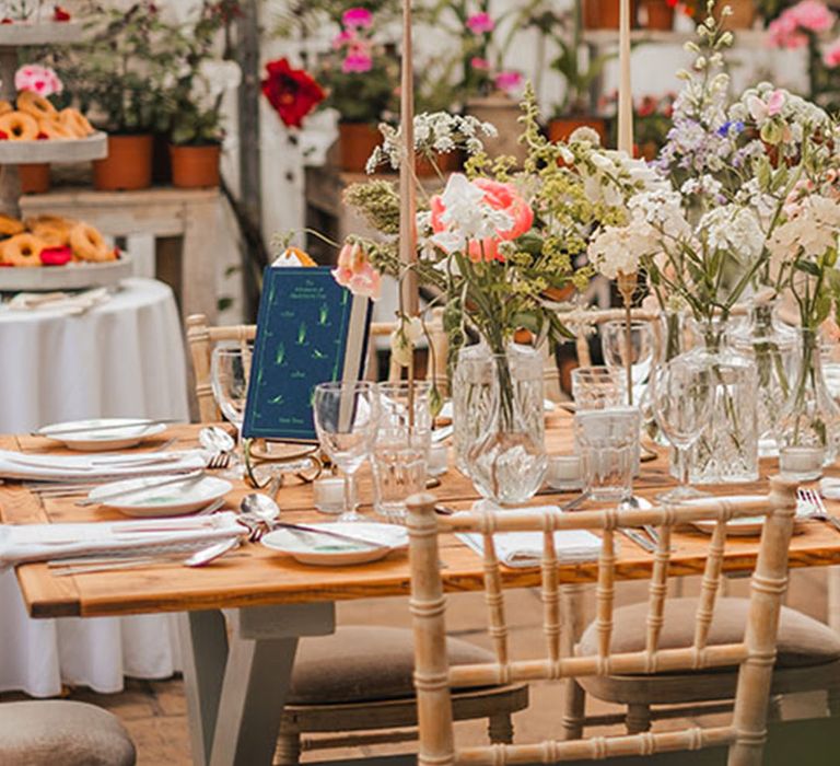 Green house wedding venue with tables named after classic literature with classic clothbound books 