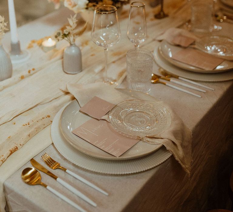 elegant place setting with muted colour palette wedding table decor, stationery and flowers 