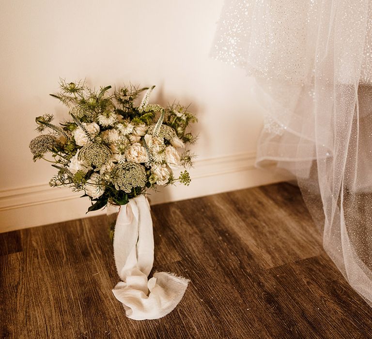 white and green wedding bouquet tied with ribbon 