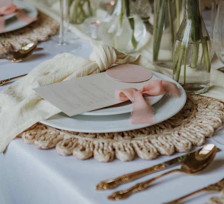 Classic white crockery on burlap wedding place mat with minimalist wedding stationery, dusky pink ribbon and yellow wedding napkins 