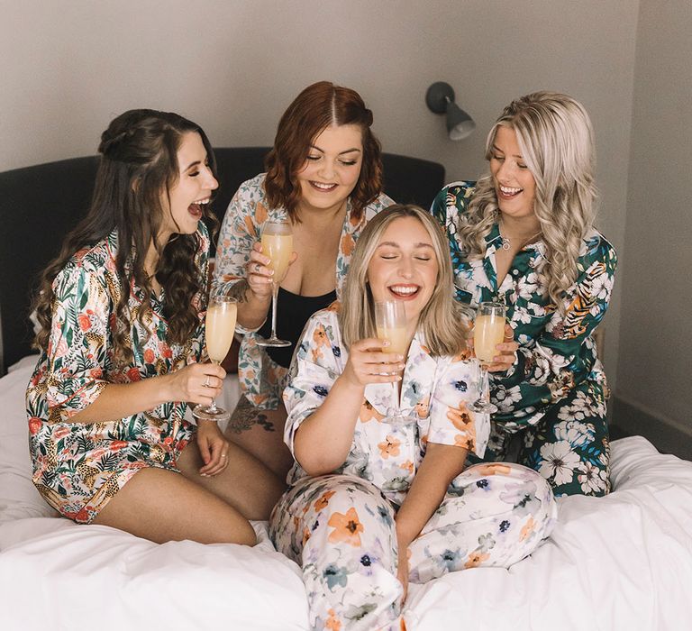 Bride and bridesmaids in floral patterned wedding pyjamas getting ready for the wedding day 