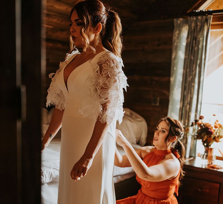 Bride wearing a Suzanne Neville wedding dress with detachable boho floral sleeves 