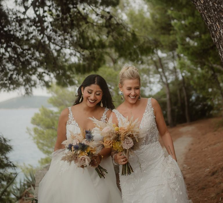 boho bride in deep v front lace wedding dresses holding pampas grass and rose wedding bouquets at Croatia wedding 