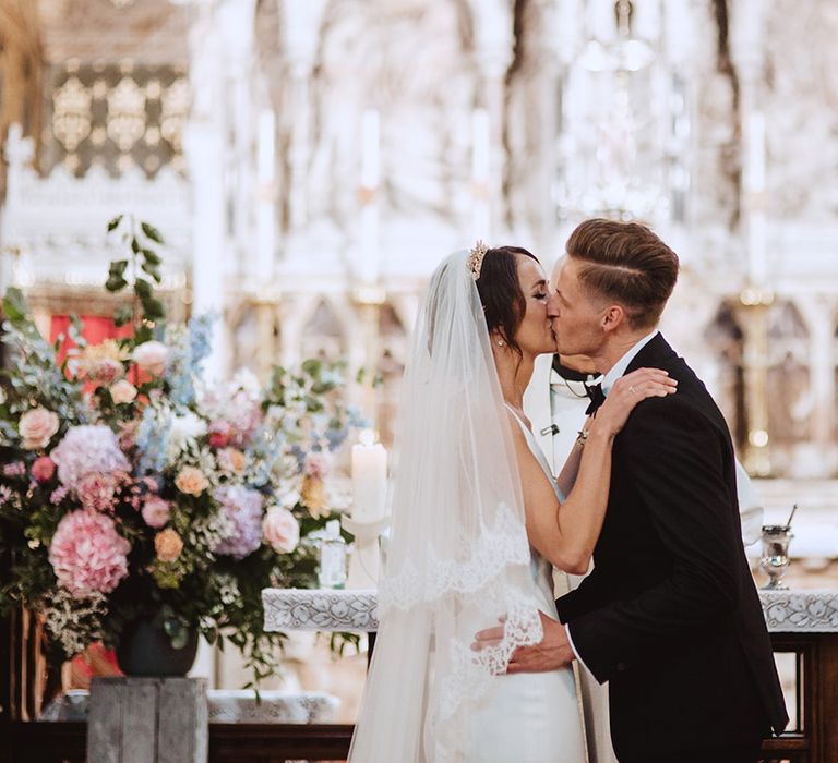 Bride wearing cathedral length veil for Catholic church wedding ceremony 