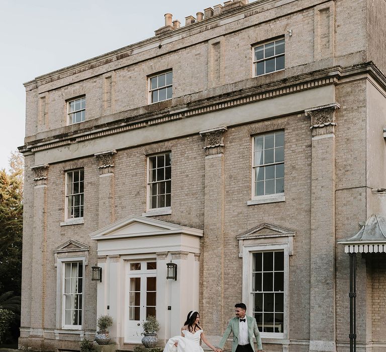 Ripple Court Estate country house winter wedding in Kent with the bride and groom in green and white outfits 