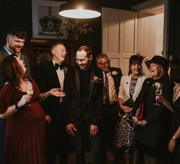 The wedding party all laugh together at the Yorkshire wedding for two grooms 