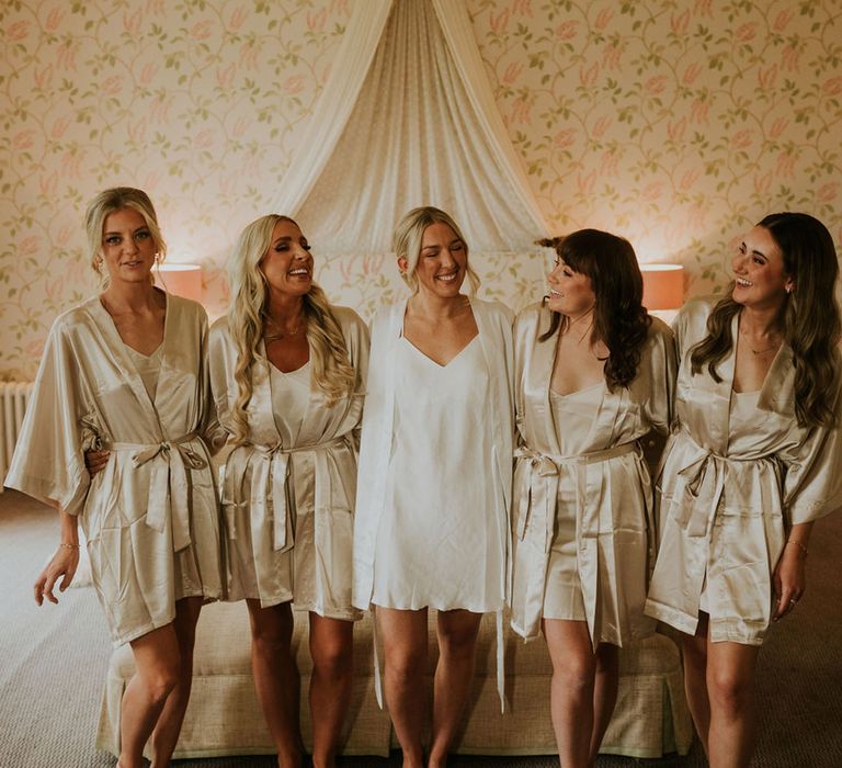 Bridal party wearing gold satin robes and pyjamas as they get ready for the wedding 