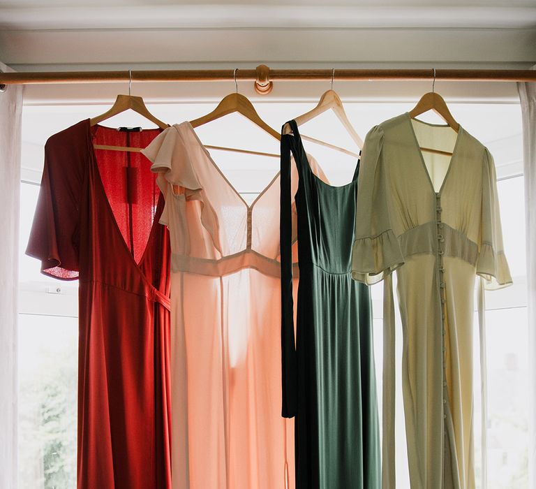 Mismatched bridesmaid dresses on hangers for the bridal party 