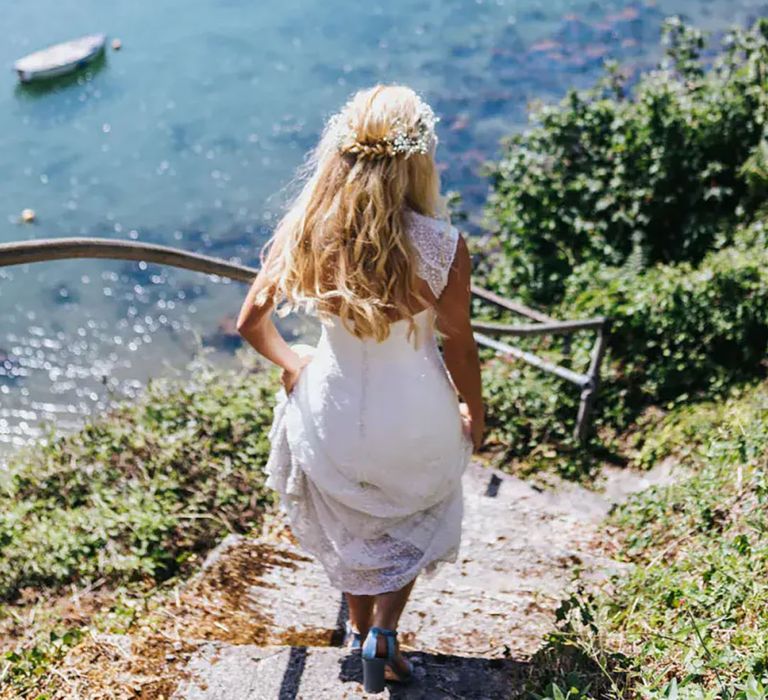 Bride walking down steps towards the sea at her coastal wedding by Lizzie Churchill Photography