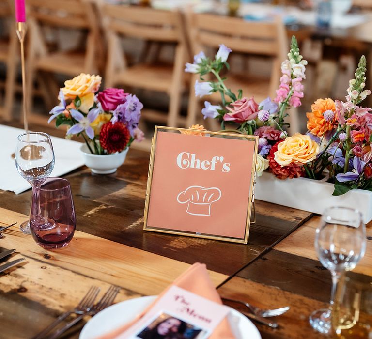 Bright flower arrangements and colourful candles decorate The Canary Shed wedding venue 