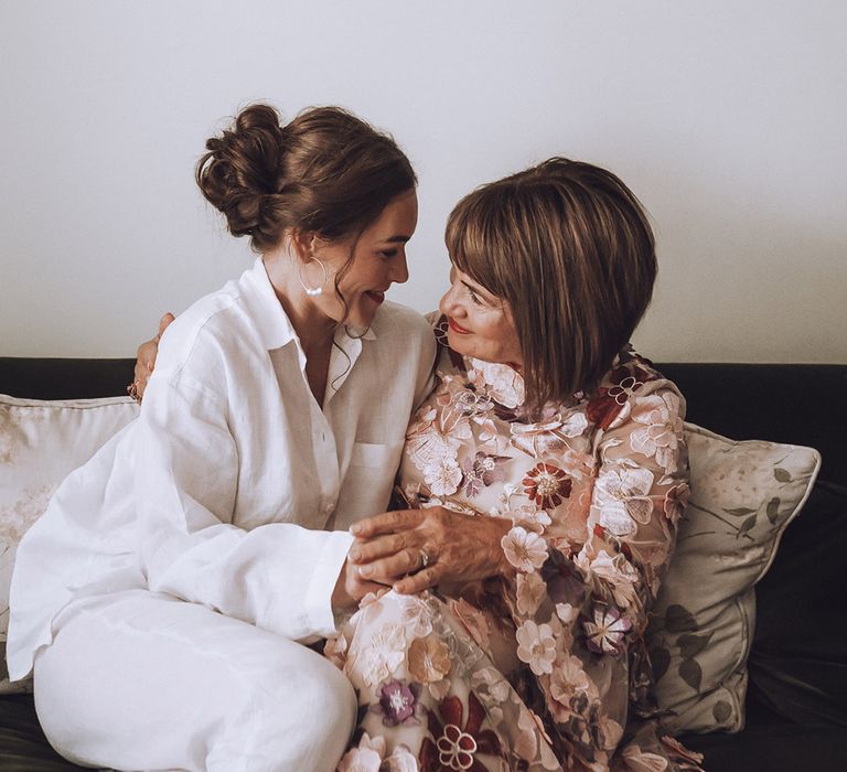 Mother of the bride in flower patterned long sleeve mother of the bride dress with bride in white long sleeve pyjamas 