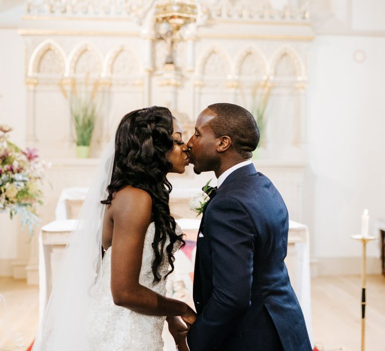 Bride and groom kissing at the altar 