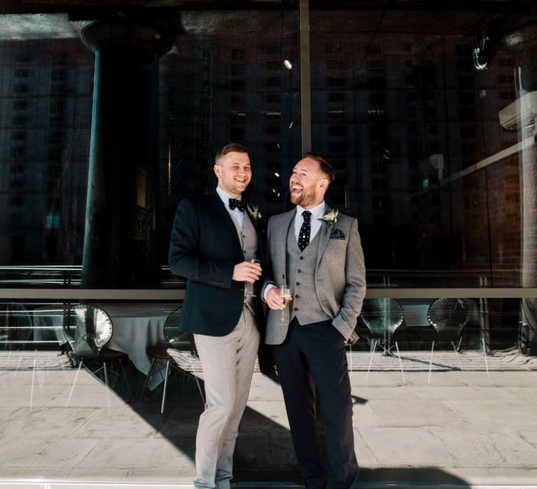 Gay wedding at the Titanic Hotel in Liverpool with Grooms stood outside laughing