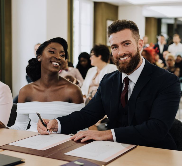 Bride and groom signing the register at civil ceremony 