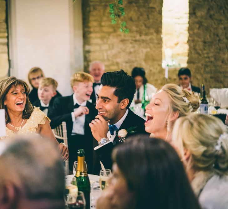 Bride and groom laughing at the top table 