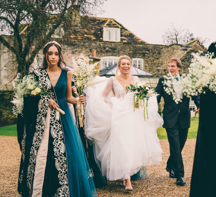 Bride and bridesmaids in teal dresses walking to the wedding venue 