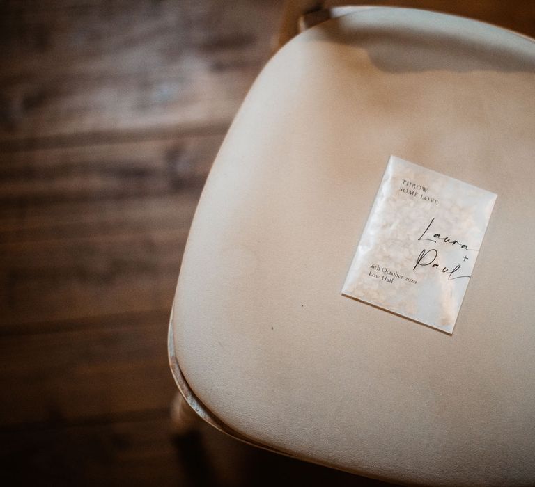 Wedding confetti on cream bamboo wedding chair