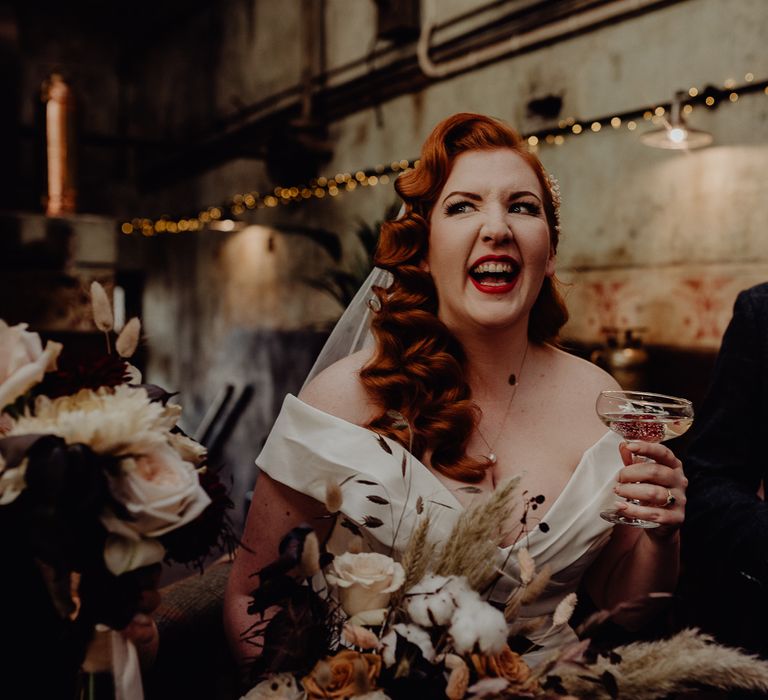 Bride with red vintage wedding hair drinking champagne 