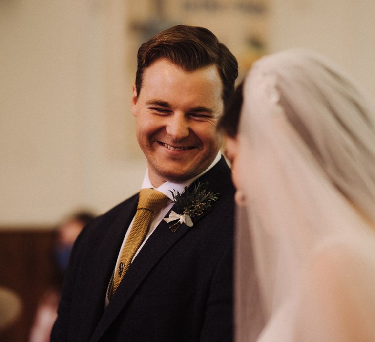 Groom smiles at bride on wedding day