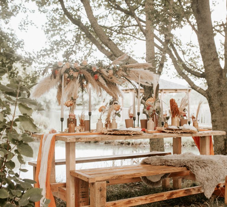 Outdoor wooden table reception with pampas grass 