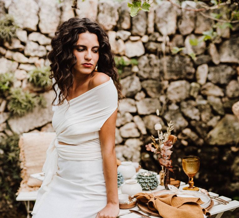 Boho bride with 80s style crimped hair and golden statement earrings