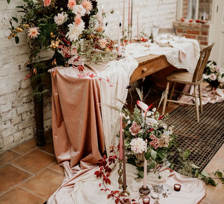 Wedding table decor with velvet tablecloth and blush pink and green wedding flower arrangements 