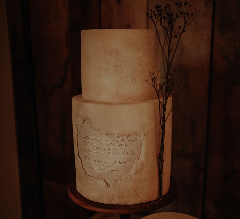 Aged two-tier wedding cake design with inscription 