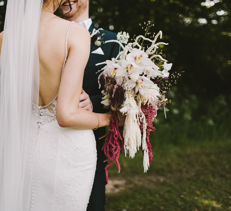 Bride holds white and dark floral bouquet